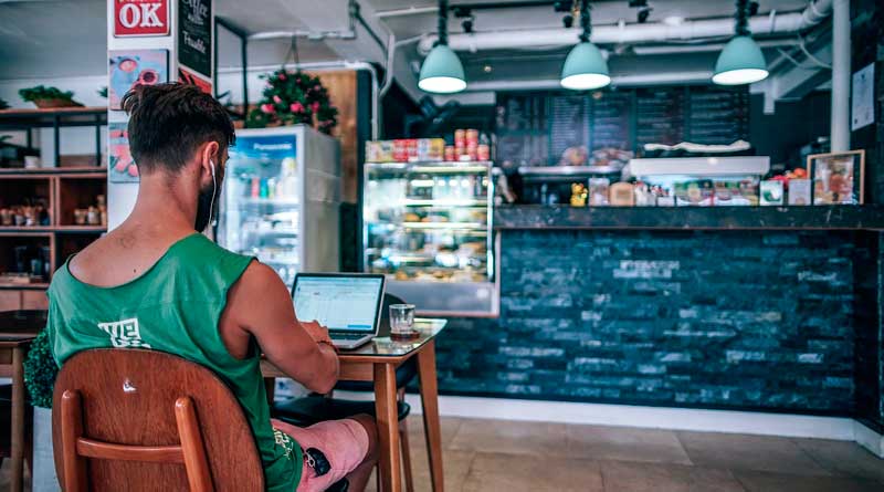 Mann mit Notebook in einem Café