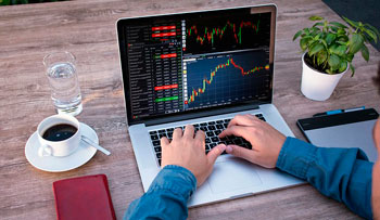 Mann am Laptop beim Forex-Trading