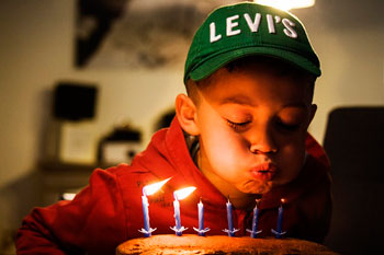 Ein Junge bläst die Kerzen auf seinem Geburtstagskuchen aus.