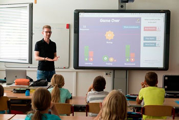 Ein Lehrer steht vor einer Klasse am Whiteboard