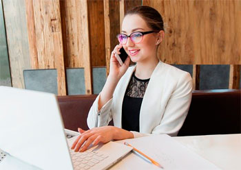 Businessfrau in Blazer und Spitzenshirt am Laptop