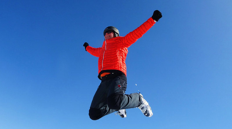 Mann in Schneeanzug springt in die Luft