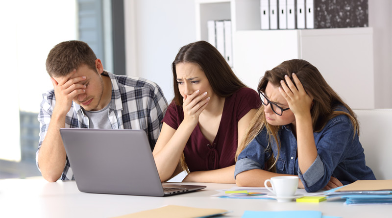 3 Mitarbeiter schauen entsetzt auf einen Bildschirm