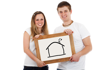 Glückliches junges Paar mit Schild, auf dem ein Haus aufgemalt ist