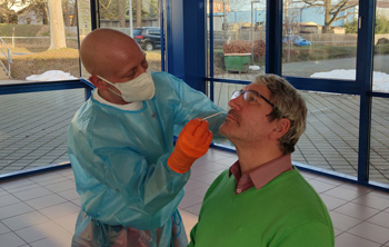 Mitarbeiter eines Testzentrums macht einen Nasenabstrich bei einem Mann