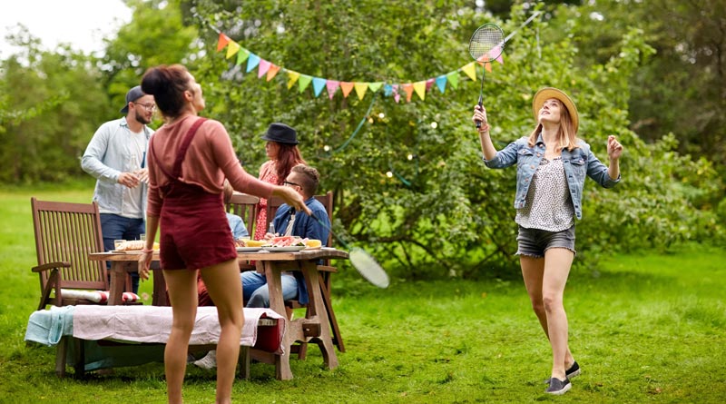 Zwei junge Frauen spielen im Garten Federball