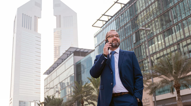 Businessman telefoniert vor dem Hintergrund der Skyline von Dubai