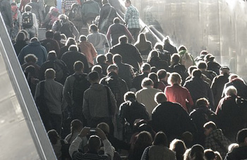 Menschenmenge verlässt über eine Treppe ein brennendes Gebäude