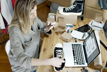 Junge Frau fotografiert Sneaker für ihren Onlineshop