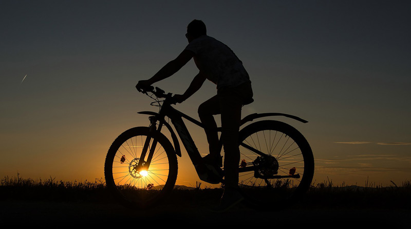e-Bike-Fahrer in der untergehenden Sonne