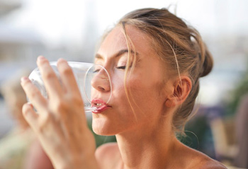 Frau trinkt Wasser aus Glas