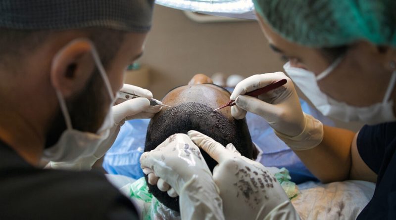 Zwei Ärzte bei einer Haartransplantation bei einem Mann