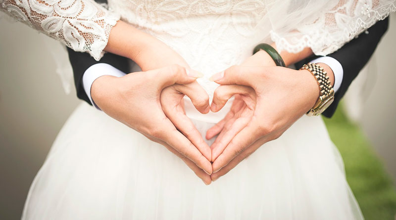 Nahaufnahme der Hände zu einem Herz geformten eines Hochzeitspaar