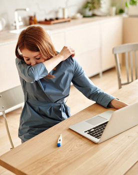 Frau mit Erkältung checkt ihre Krankheitssymptome online