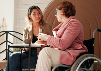 Frau im Rollstuhl mit persönlicher Asistentin