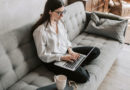 Junge Frau sitzt auf dem Sofa und bewirbet sich über ein Job-Portal online