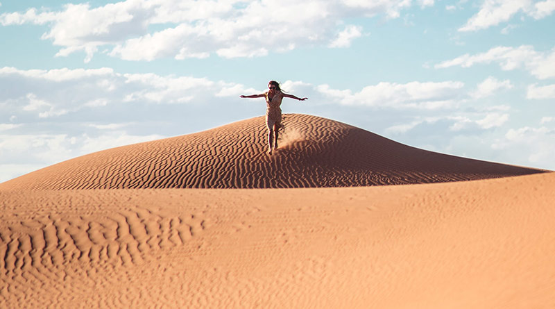 Junge Frau auf einer Sanddüne in der Sahara