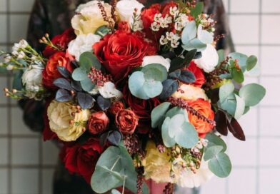 Ausschnitt einer Frau, die einen üppigen Blumenstrauß in den Händen hält.