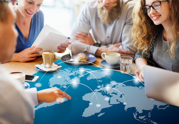 Menschen besprechen an einem Tisch eine digital dargestellte Weltkarte