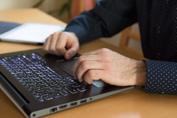 Mitarbeiter organisiert Sicherheitsabläufe an einem Laptop