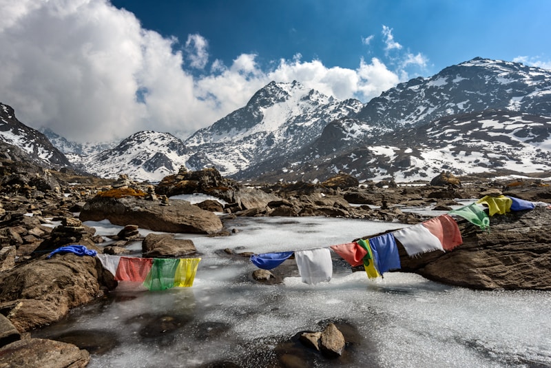 Schneebedeckte Himalaya-Berge mit Gebetsfahnen; Foto: Sergey Pesterev, Unsplash