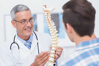 Orthopäde erklärt Patient Aufbau der Wirbelsäule