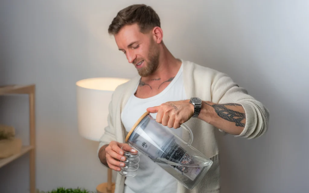 Ein Mann entnimmt Wasser aus einem Wasserfilter