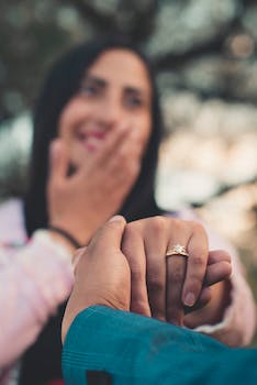 Überraschte Frau mit Verlobungsring nach dem Heiratsantrag