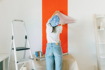 Junge Frau tapeziert Wand