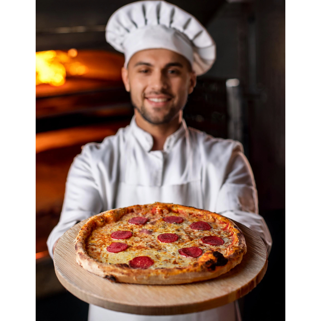 Junger Mann vor einem Pizzaofen mit einer frisch gebackenen Pizza.