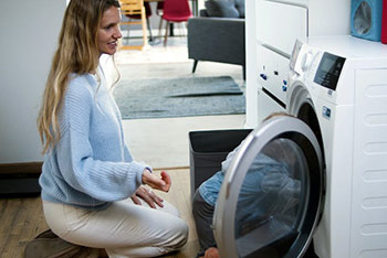 Frau befüllt ihre Waschmaschine