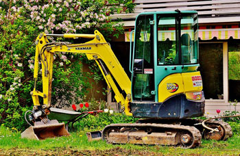 Bagger beim Ausheben von Erde in einem Garten