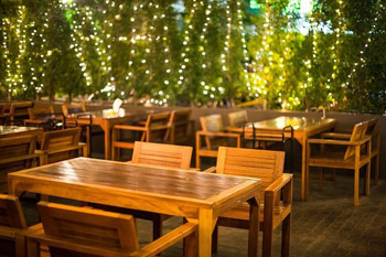 Außenbereich eines Restaurants mit schicken Möbeln und Lichterketten