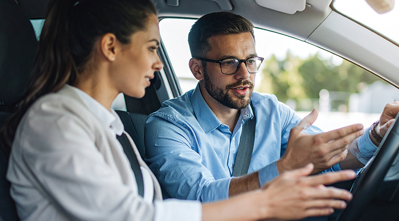 Ein Fahrlehrer mit seiner Schülerin in einem Auto
